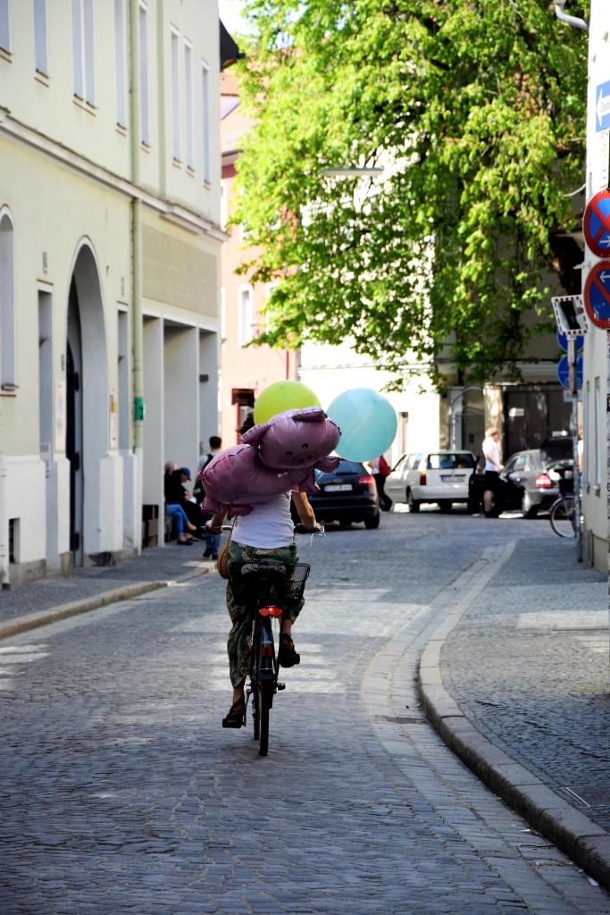 Schwein gehabt! Radlerin unterwegs mit Ballons in der Regensburger Altstadt