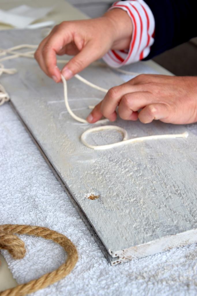 Jetzt werden die Buchstaben aufs Holzschild geklebt