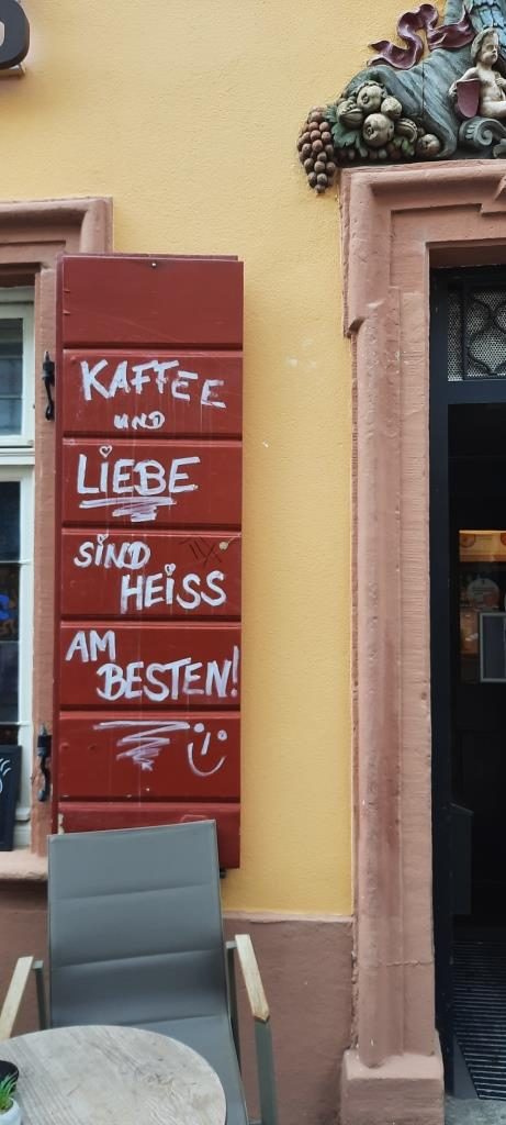 Rote Holzfensterläden an einem Café mit der Aufschrift "Kaffee und Liebe sind heiß am besten" - Heidelberg - 12von12 im Februar 2025 - Unterfreundenblog