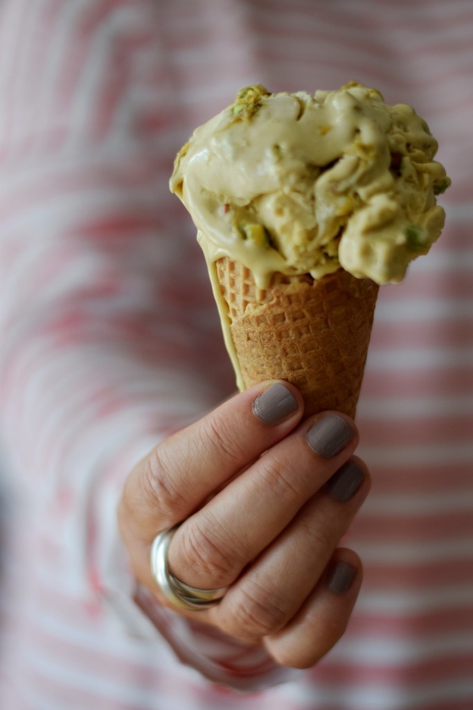 Frauenhand hält Eiswaffel mit Pistazieneis