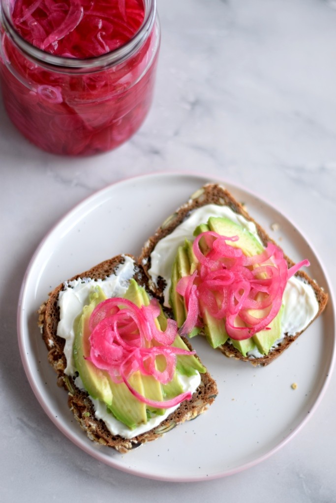 Körnerbrot belegt mit Avocado und pinken Zwiebeln